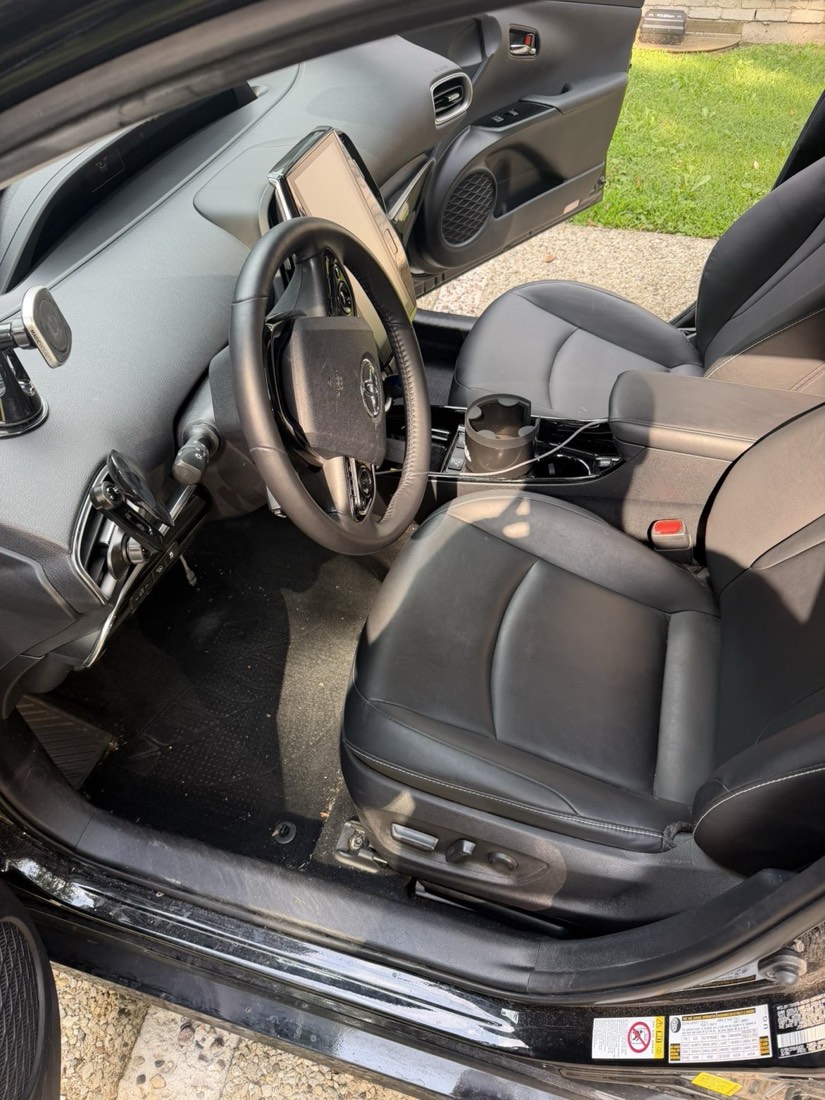 Detailed driver seat and steering wheel of a black Toyota Prius